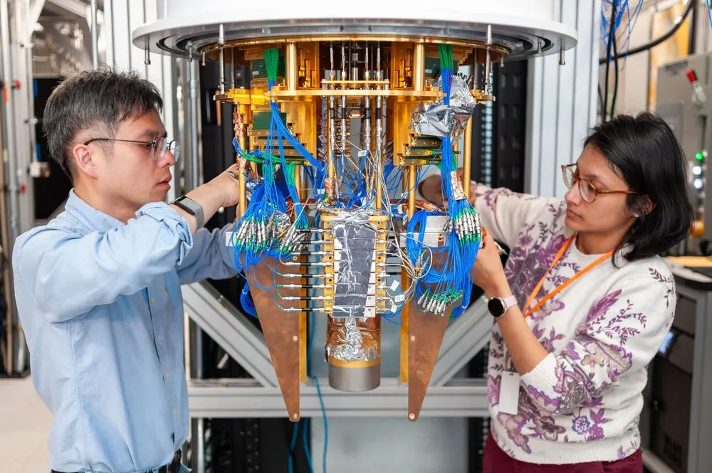 量子コンピュータの冷凍機内部を調整する二人の研究者