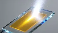 レーザーで加工される金色の基板