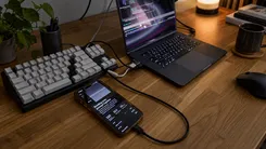 ノートPC、キーボード、スマートフォンが置かれたデスク